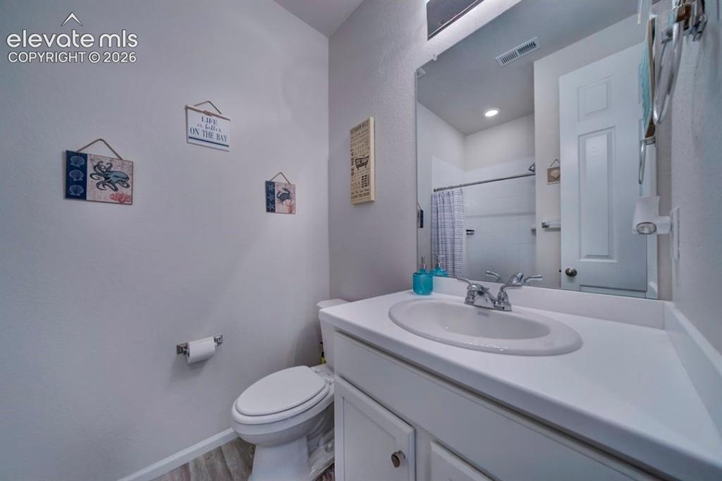 Image 30 of 34: Vanity with an integrated sink, polished chrome faucet, and white cabinetry