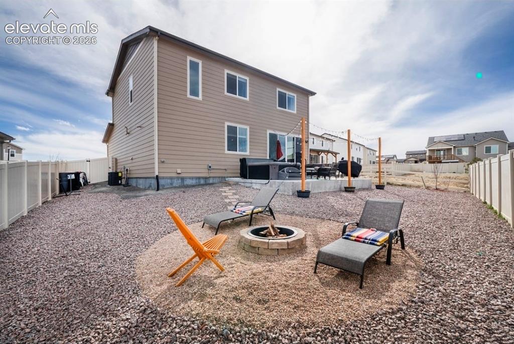 Image 34 of 34: Expansive backyard featuring a gravel landscape, privacy fencing, a built-i