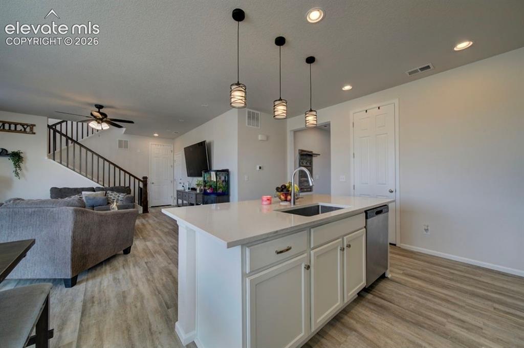 Image 6 of 34: Kitchen island with a built-in sink, stainless steel dishwasher, and white 
