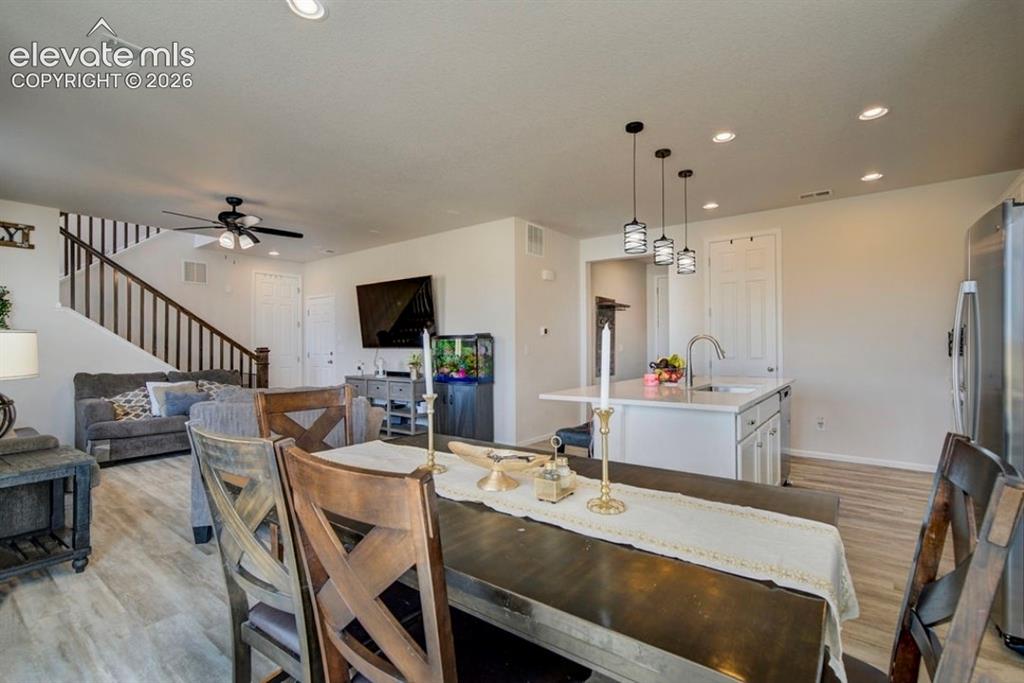 Image 7 of 34: Open-concept living space featuring wood-finish flooring, recessed lighting