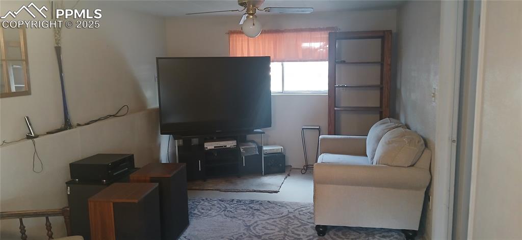 Image 18 of 33: Living room featuring a ceiling fan