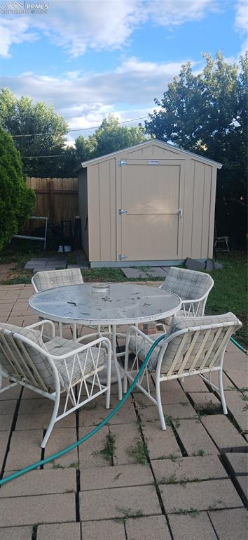 Image 28 of 33: View of patio / terrace featuring a storage unit and outdoor dining space