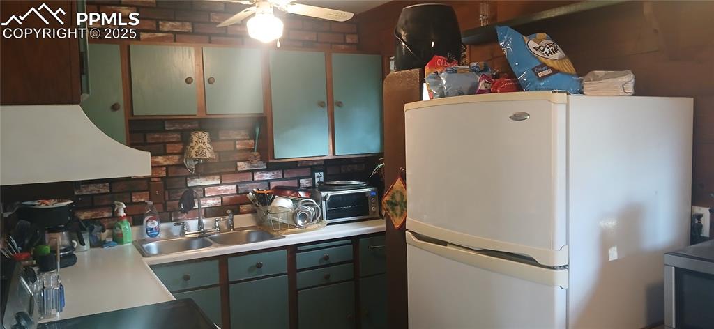 Image 8 of 33: Kitchen featuring green cabinetry, freestanding refrigerator, ceiling fan,