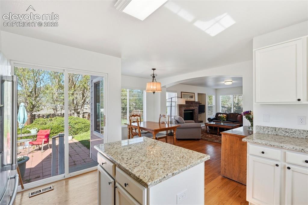 Image 11 of 37: Kitchen featuring a central island with a granite countertop, white cabinet