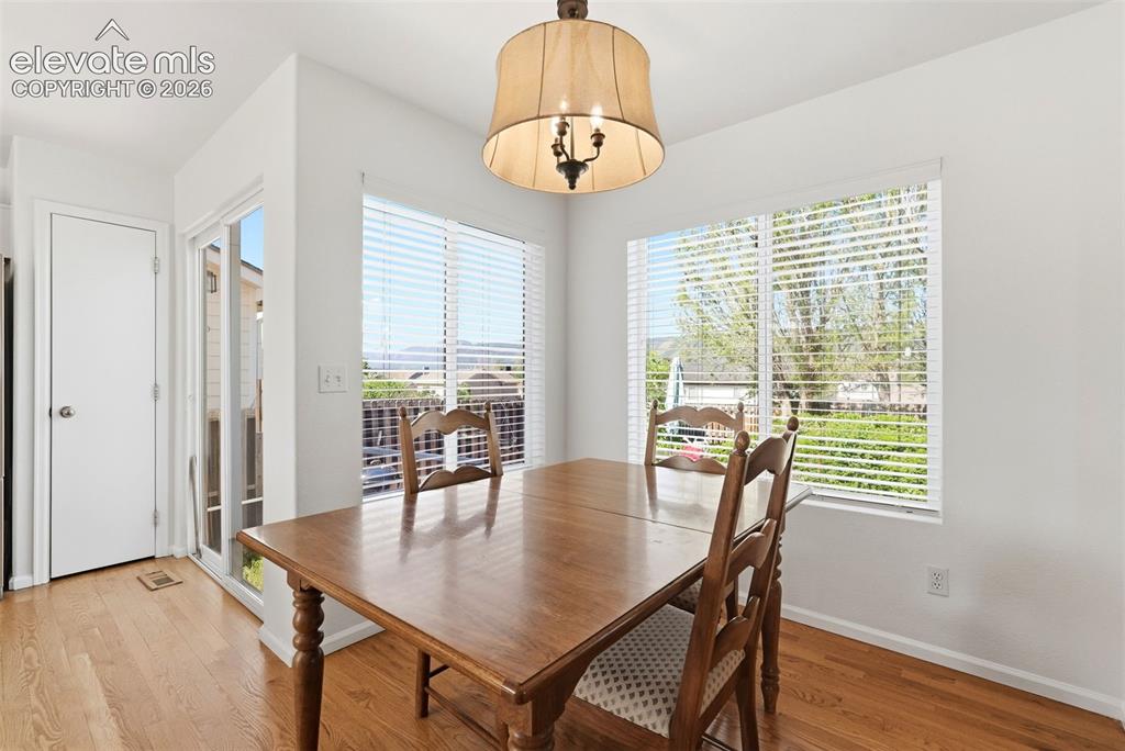 Image 15 of 37: Dining area featuring wood-finish flooring, a contemporary chandelier, and