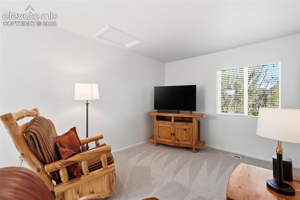 Image 18 of 37: Carpeted room with a rectangular window and white horizontal blinds