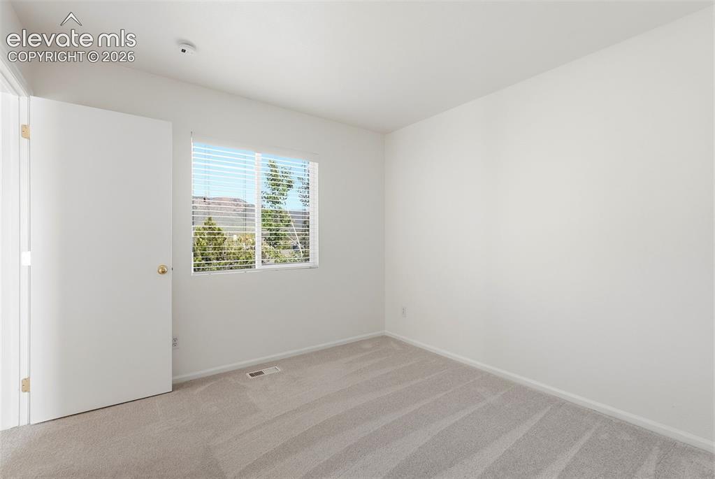 Image 20 of 37: Room featuring a bright window with horizontal blinds, neutral-toned carpet
