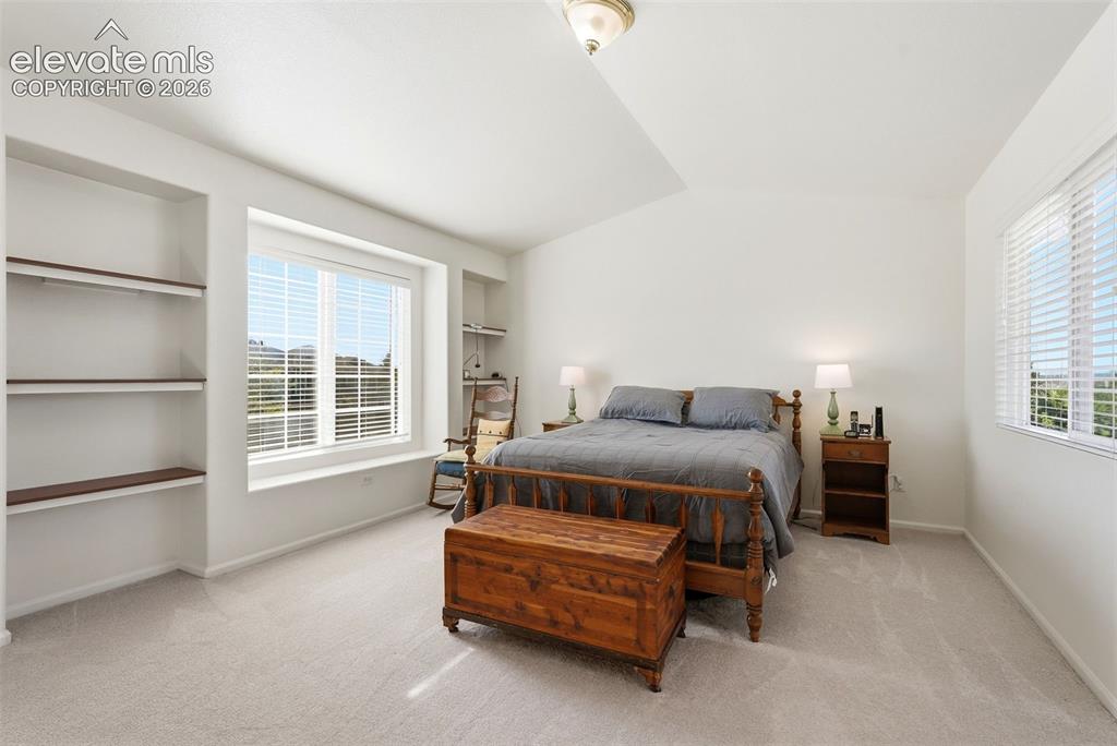 Image 24 of 37: Carpeted bedroom featuring a vaulted ceiling and a built-in window seat