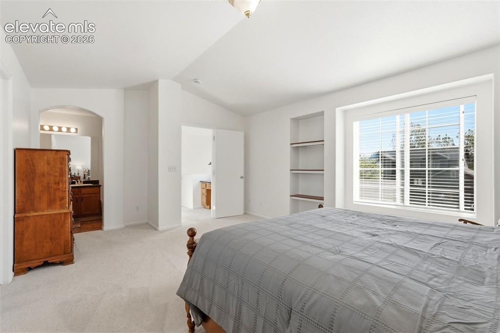 Image 25 of 37: Spacious room featuring light-colored carpeting, a large window with white