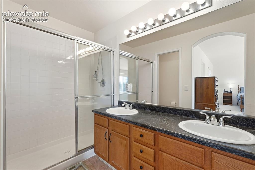 Image 27 of 37: Double vanity featuring integrated sinks and a dark-toned countertop