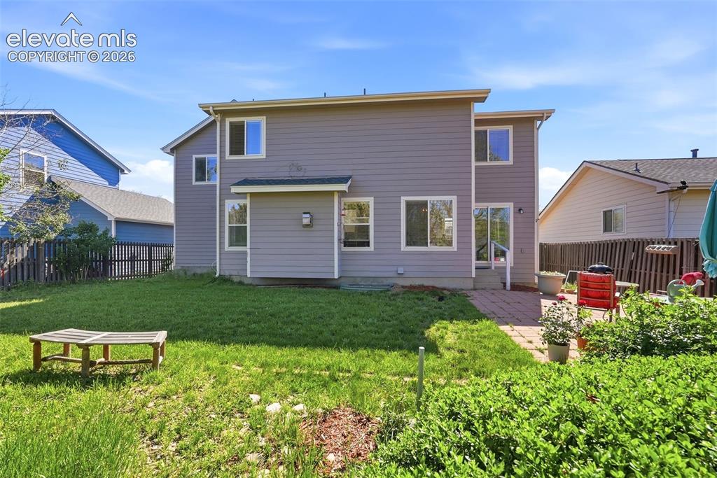 Image 30 of 37: Rear exterior featuring gray siding, a two-story design, multiple windows,