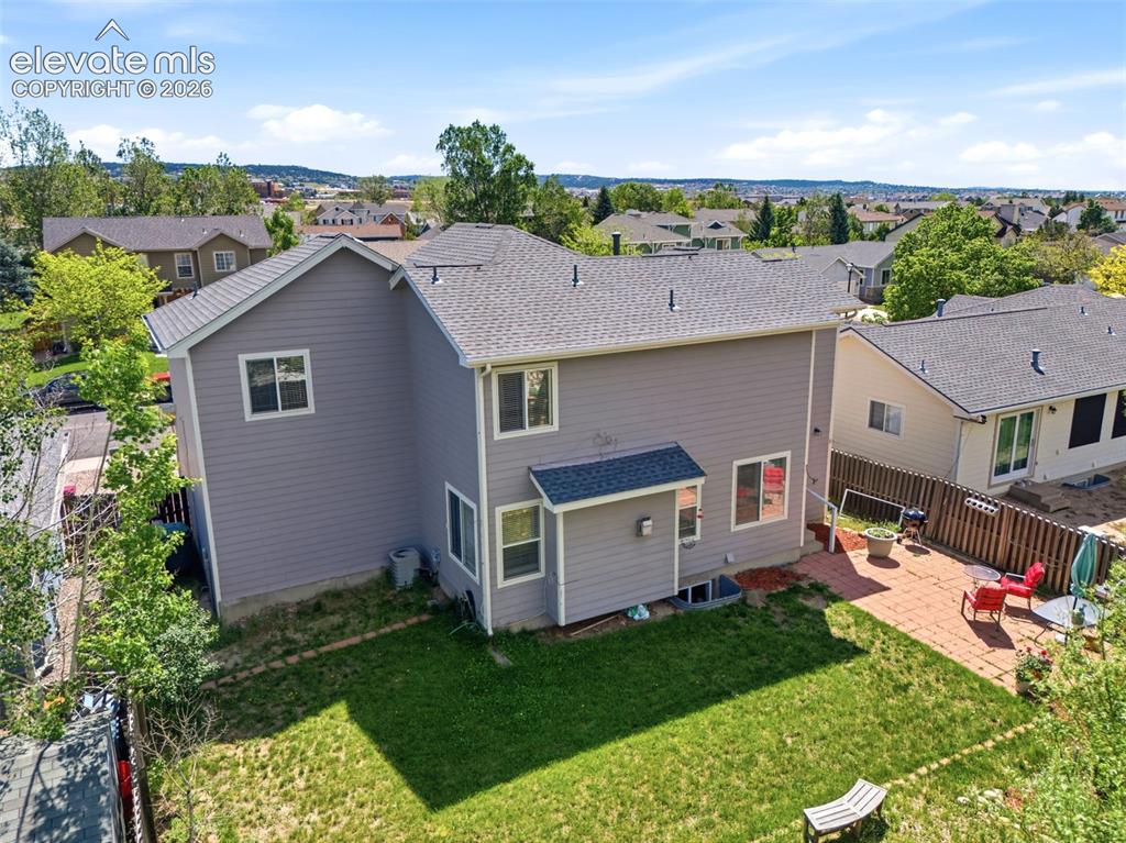 Image 33 of 37: Rear exterior showcasing a two-story residence with light gray siding and a
