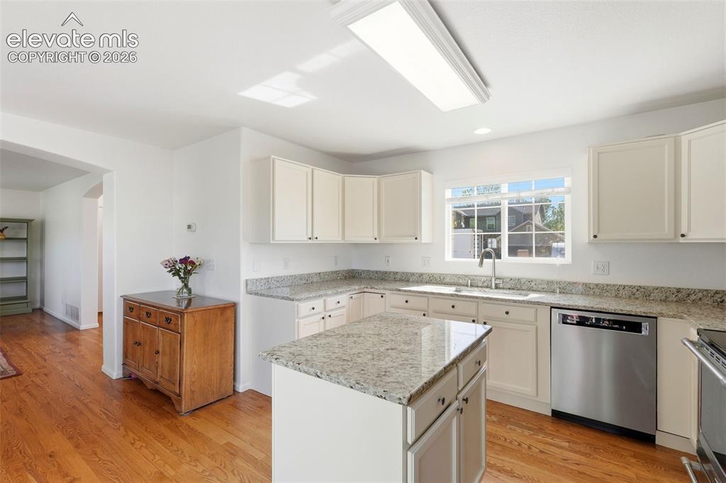 Image 8 of 37: Kitchen featuring white cabinetry, light-toned countertops, a center island