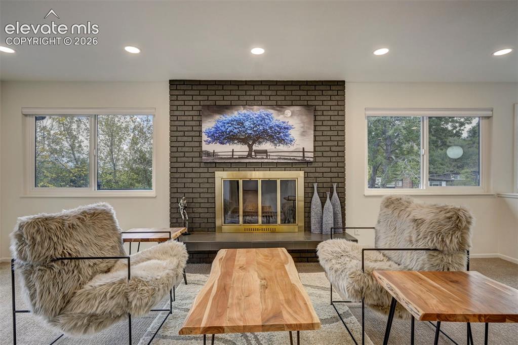 Image 11 of 50: Floor-to-ceiling dark brick fireplace feature with a metal screen and stone