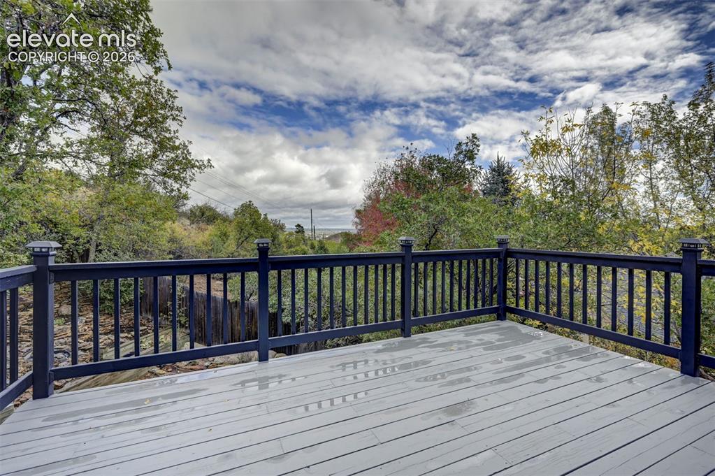 Image 14 of 50: Elevated deck featuring gray-tone decking, dark-painted balustrades, and su