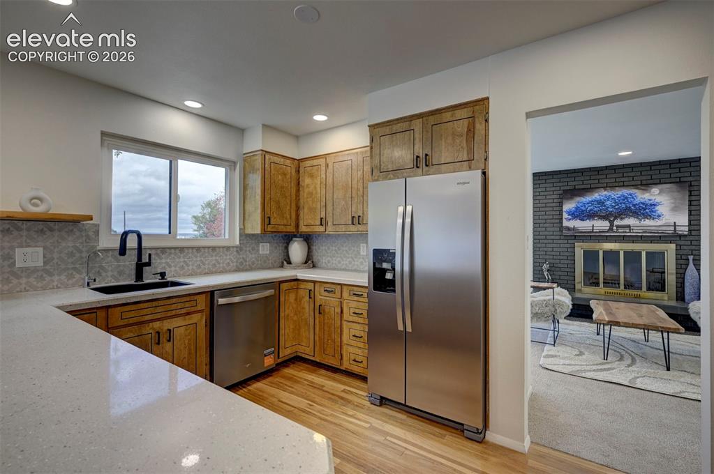 Image 18 of 50: Kitchen featuring wood cabinetry, solid-surface countertops, stainless stee