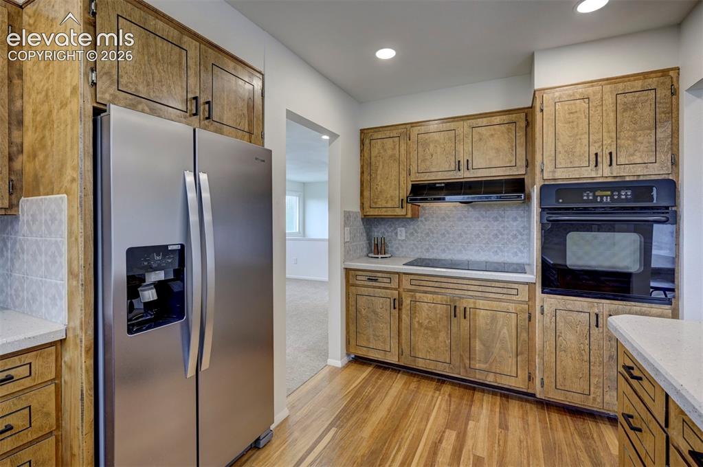 Image 19 of 50: Kitchen featuring wood-finish cabinetry, stainless steel side-by-side refri