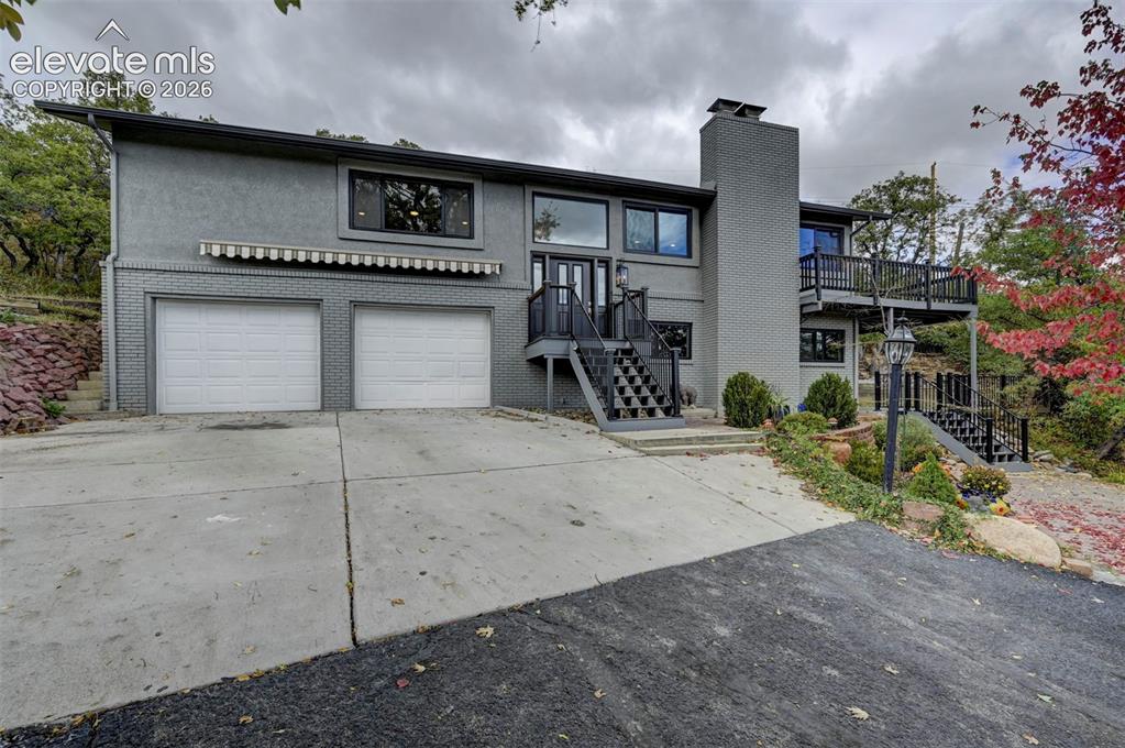 Image 2 of 50: Multi-level exterior featuring a painted brick facade, integrated two-car g