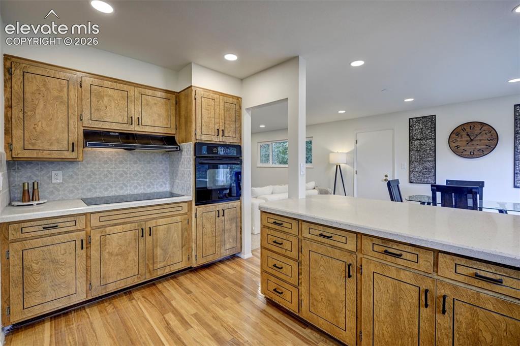 Image 20 of 50: Kitchen featuring wood cabinetry, recessed lighting, built-in double wall o