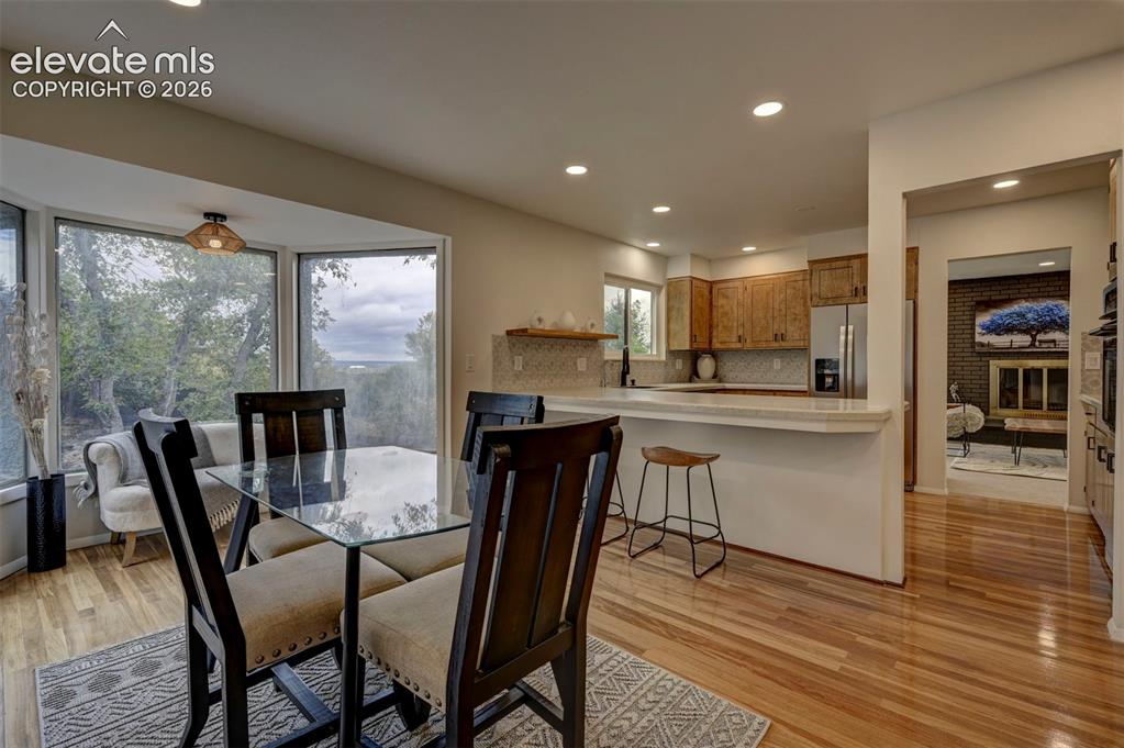 Image 21 of 50: Kitchen featuring wood cabinetry, recessed lighting, a raised countertop br