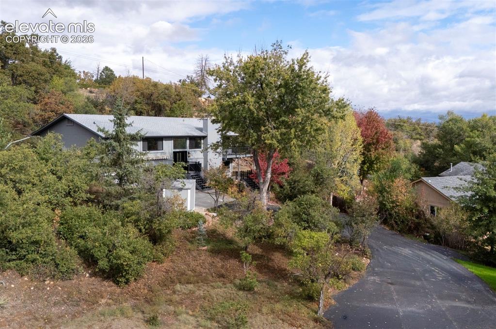 Image 3 of 50: Multi-level residence featuring a pitched roof, metal siding, expansive har