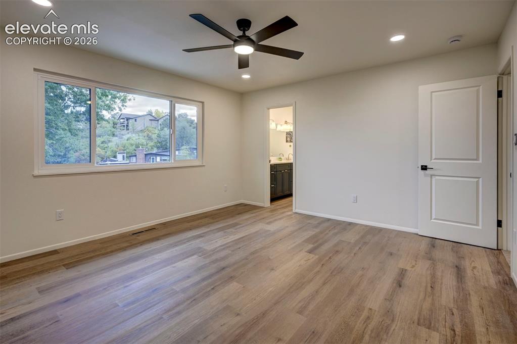 Image 32 of 50: Interior room featuring wood-finish flooring, a large multi-pane window, re