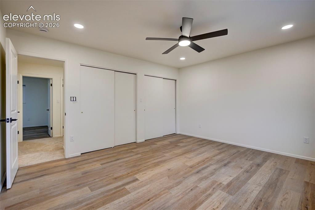 Image 33 of 50: Room featuring wood-finish flooring, dual sliding-door closets, recessed li