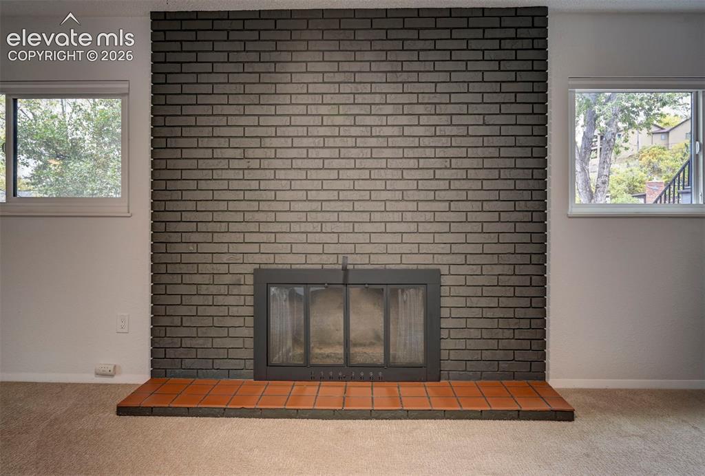 Image 40 of 50: Floor-to-ceiling dark brick fireplace surround with a metal firebox insert