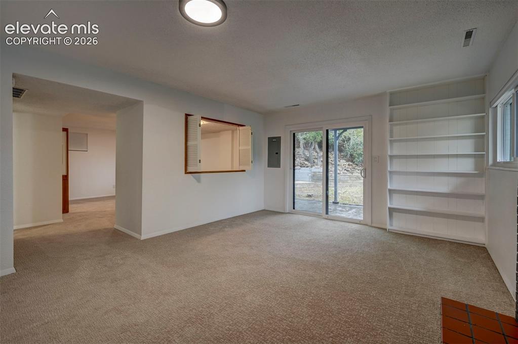 Image 41 of 50: Built-in shelving, pass-through wall window with shutter doors, and sliding
