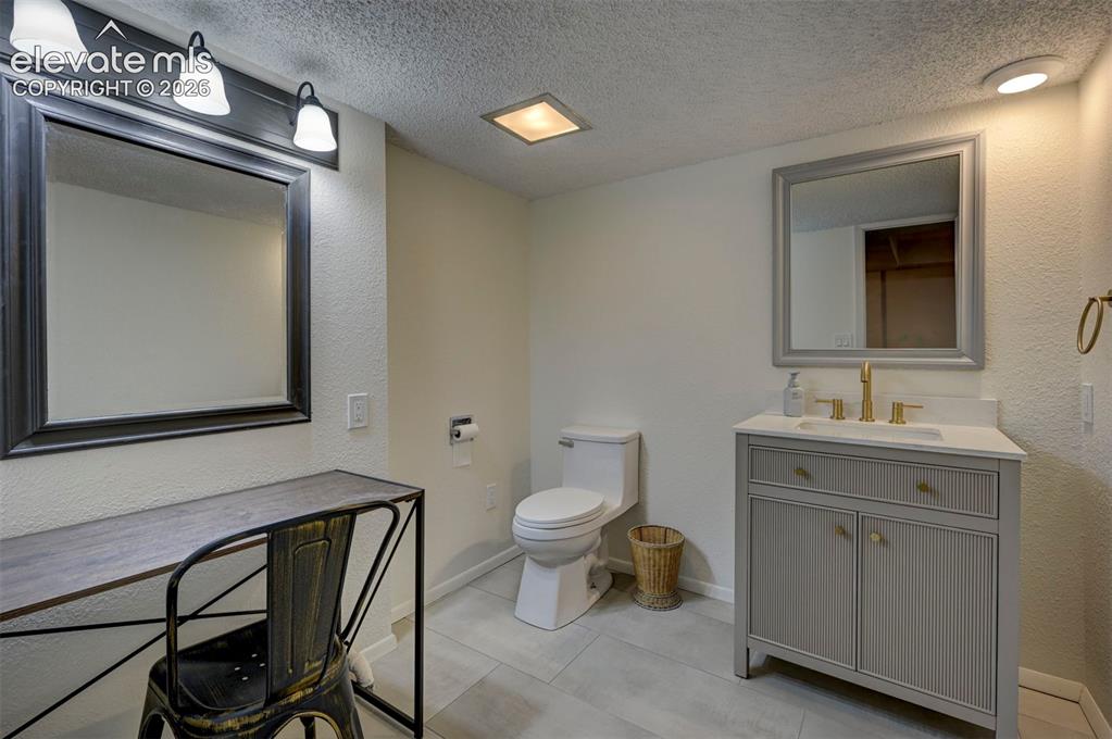 Image 43 of 50: Bathroom featuring a vanity with a light-colored countertop and integrated