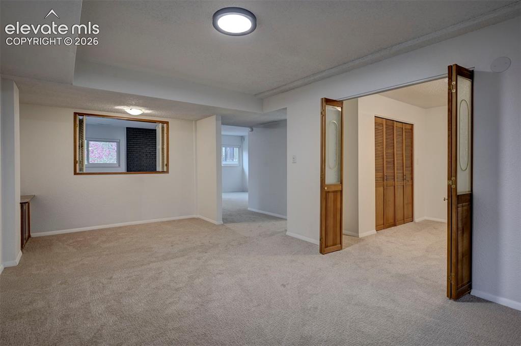 Image 44 of 50: Neutral-toned wall-to-wall carpeting, recessed ceiling lighting, louvered w