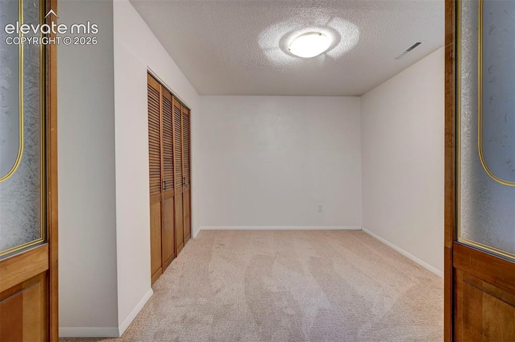 Image 45 of 50: Interior space featuring neutral wall tones, wall-to-wall carpeting, wood-f