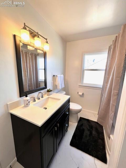 Image 14 of 25: Full bathroom featuring vanity, plenty of natural light, and light marble f