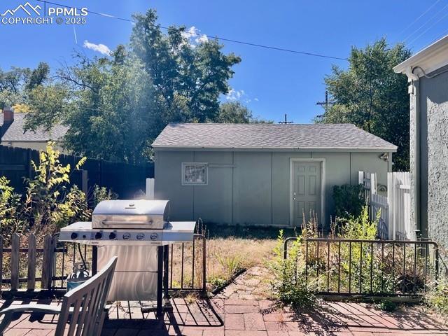 Image 16 of 25: View of patio / terrace featuring area for grilling and an outbuilding