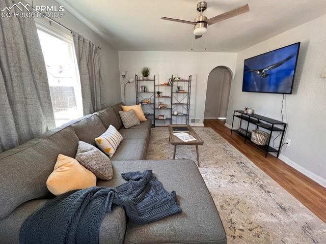 Image 5 of 25: Living room featuring wood floors, arched walkways, a textured wall, and a 