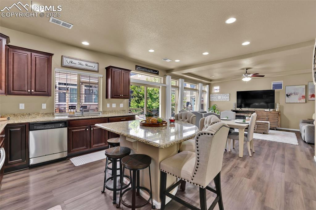 Image 15 of 50: Kitchen featuring a breakfast bar area, recessed lighting, visible vents, d