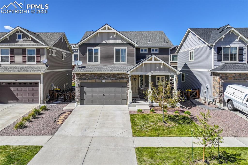 Image 2 of 50: Craftsman-style house with a porch, an attached garage, concrete driveway,