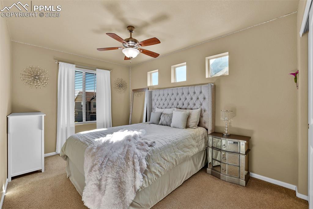 Image 25 of 50: Carpeted bedroom with ceiling fan
