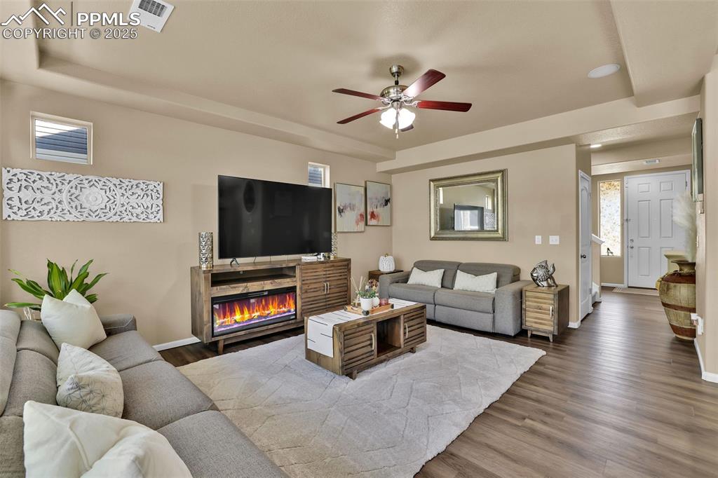 Image 8 of 50: Living area with a wealth of natural light, ceiling fan, and lvp finished f