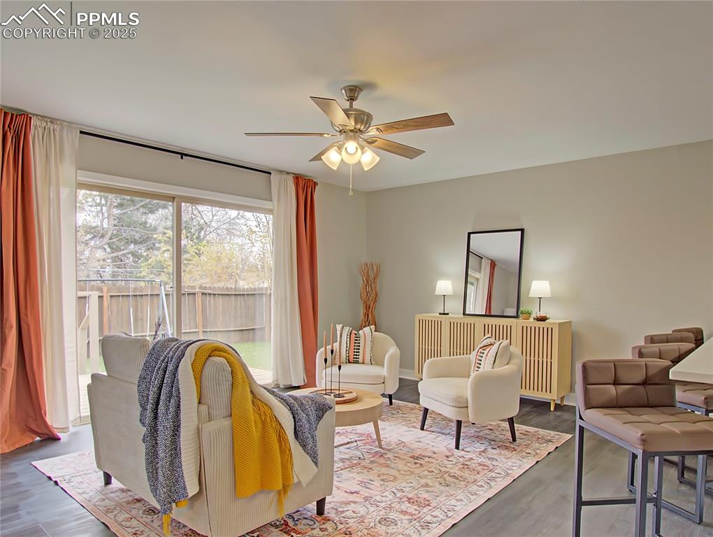 Image 12 of 26: Living room featuring ceiling fan and wood finished floors