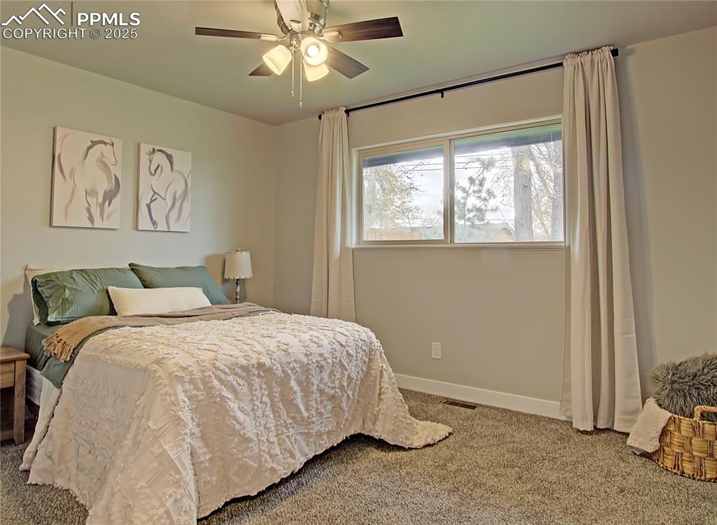 Image 18 of 26: Bedroom with carpet flooring and a ceiling fan
