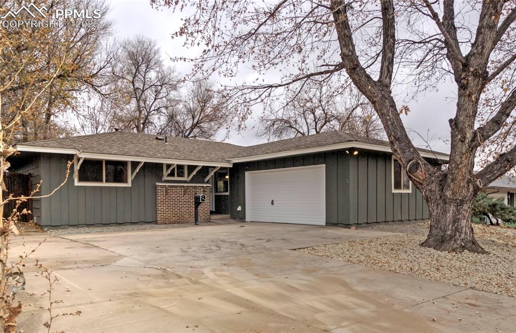 Image 2 of 26: View of front of home featuring concrete driveway, a shingled roof, board a