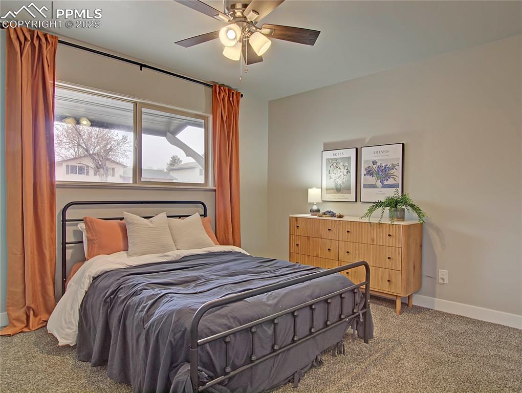 Image 20 of 26: Bedroom with carpet floors and a ceiling fan