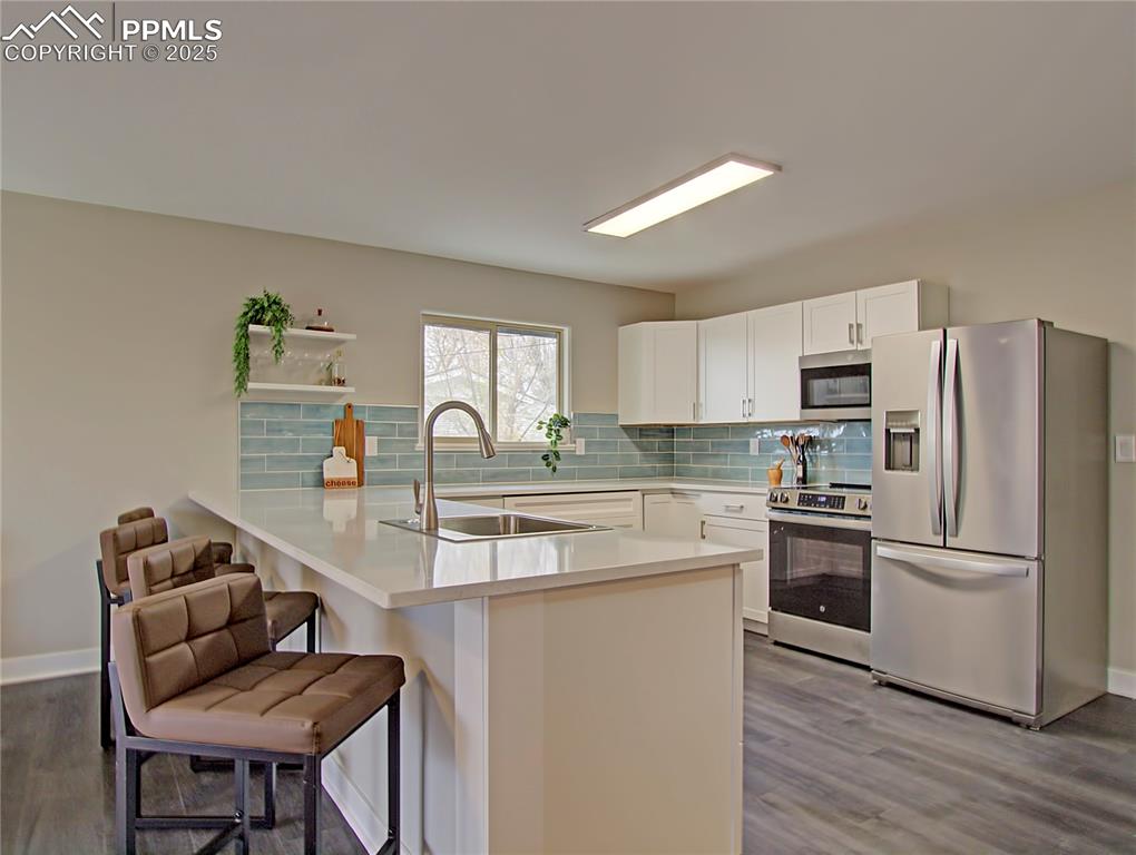Image 7 of 26: Kitchen with appliances with stainless steel finishes, dark wood finished f