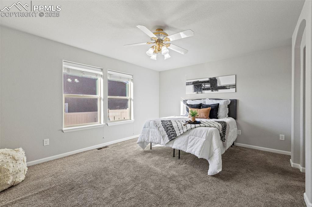 Image 14 of 42: Carpeted bedroom with a ceiling fan and baseboards