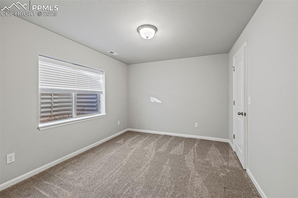 Image 26 of 42: Spare room with light carpet and a textured ceiling