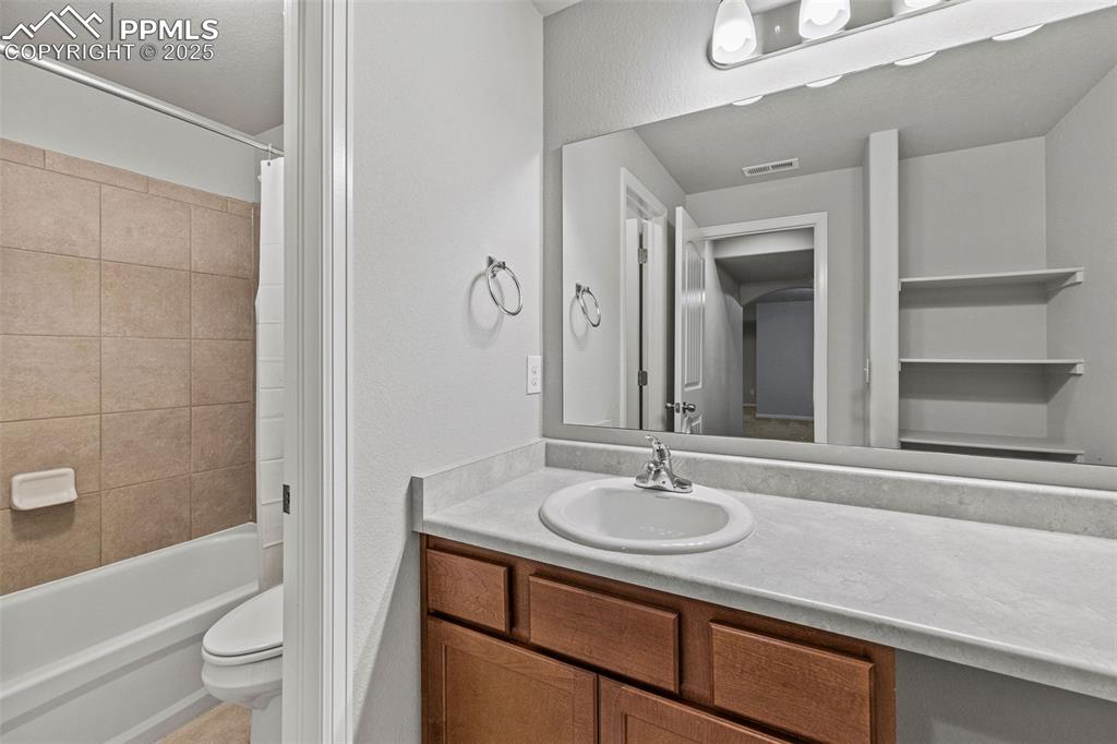 Image 27 of 42: Full bathroom featuring vanity, shower / tub combo with curtain, and a text