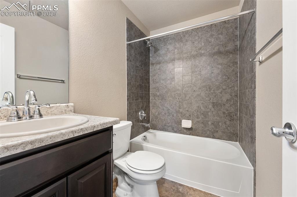 Image 10 of 25: Bathroom featuring vanity, shower combination, and a textured wall