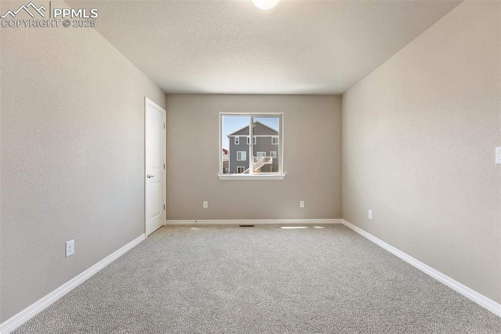 Image 12 of 25: Empty room featuring carpet and baseboards