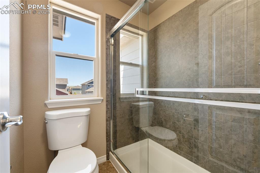 Image 14 of 25: Bathroom featuring toilet and a shower stall